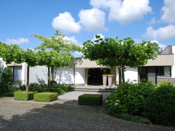 Voie d’accès avec vue sur une villa moderne et intemporelle à Hasselt.